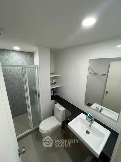 Modern bathroom with sleek fixtures and glass shower enclosure