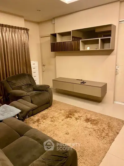 Cozy living room with plush seating and modern wall-mounted storage unit.
