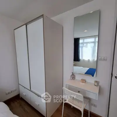 Modern bedroom with sleek wardrobe and stylish vanity area, perfect for urban living.
