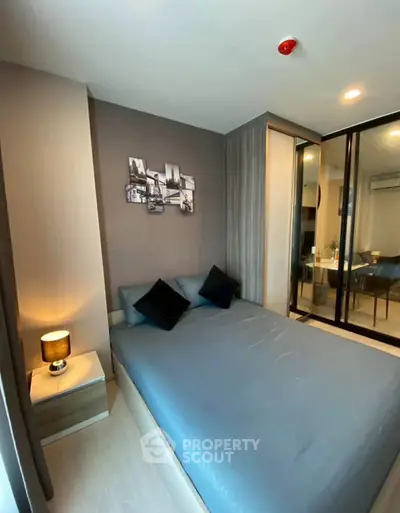 Modern bedroom with stylish decor and mirrored wardrobe in a cozy apartment.