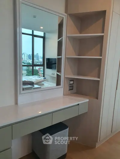 Modern bedroom with built-in vanity and shelves, offering a stylish and functional space with city view.