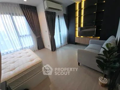 Modern bedroom with stylish decor, large windows, and cozy seating area.