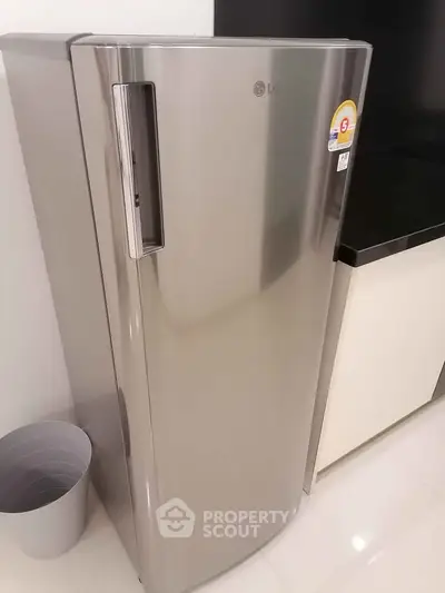 Modern kitchen with sleek stainless steel refrigerator and minimalist design.