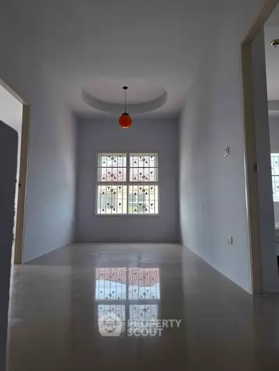 Spacious empty room with modern lighting and polished floors, ideal for customization.