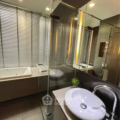 Luxurious modern bathroom with glass shower and bathtub, sleek design and ambient lighting.