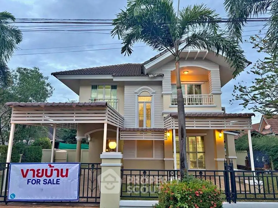 Charming two-story house with lush garden and sale sign, perfect for family living.