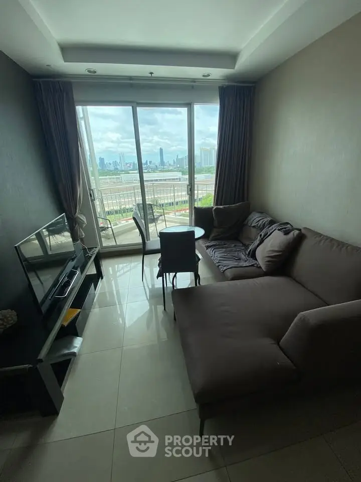 Modern living room with large windows offering stunning city skyline views.