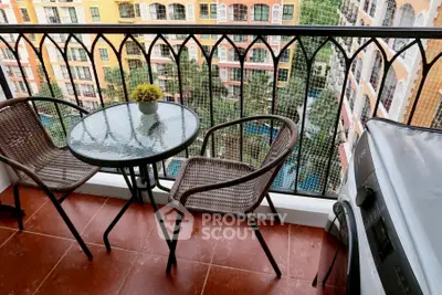 Charming balcony with cozy seating and scenic view of colorful buildings and lush greenery.