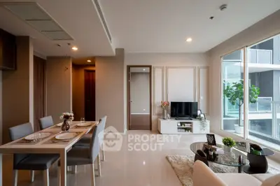 Modern living room with dining area and large windows in a stylish apartment.