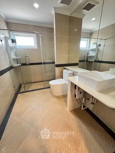 Spacious modern bathroom with glass shower and elegant fixtures