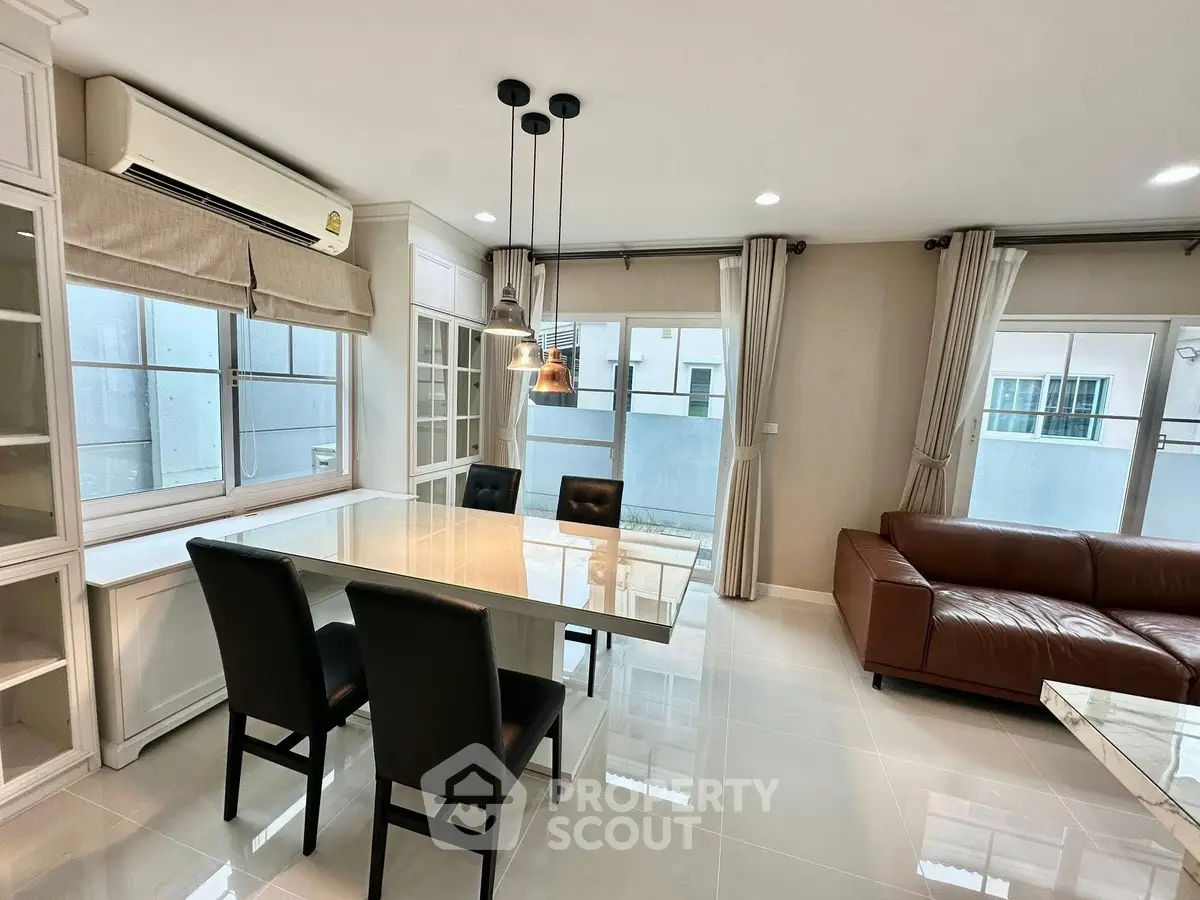 Modern living room with sleek furniture and large windows offering ample natural light.