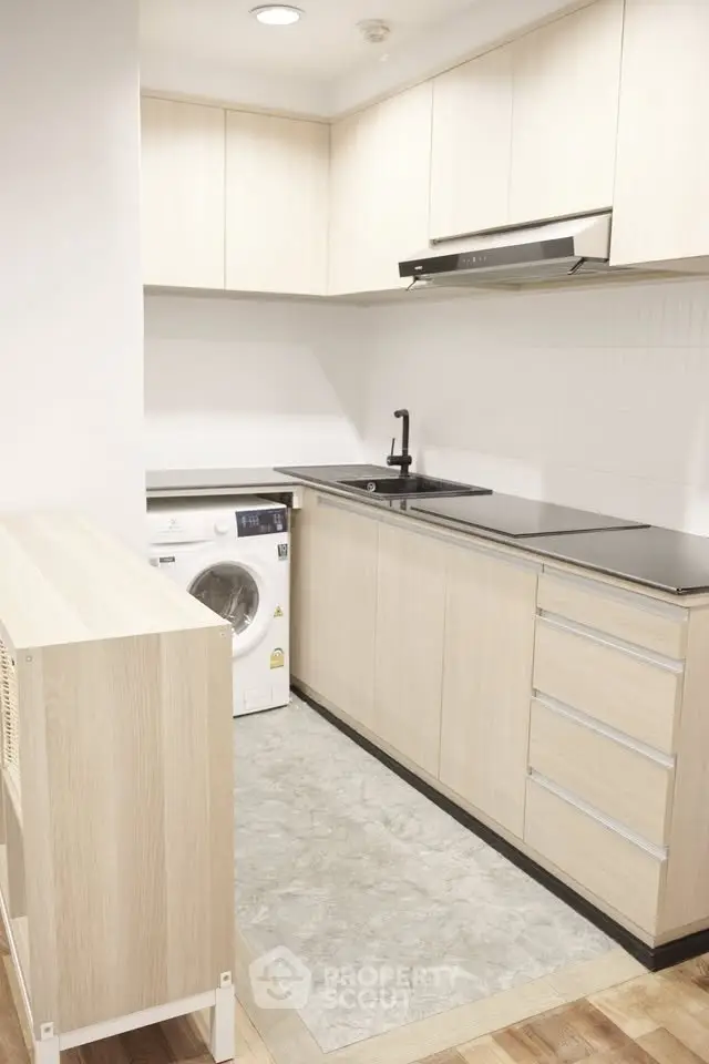 Modern kitchen with sleek cabinetry and built-in washing machine