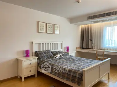 Spacious bedroom with modern decor and natural light, featuring a comfortable bed and stylish furnishings.