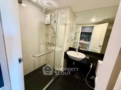 Modern bathroom with glass shower and sleek fixtures in a contemporary apartment.