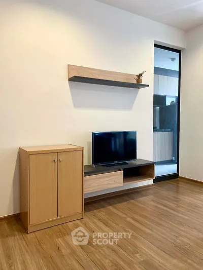Modern living room with sleek wooden flooring and minimalist TV setup