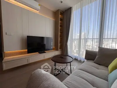 Modern living room with large window and stylish furniture in high-rise apartment.