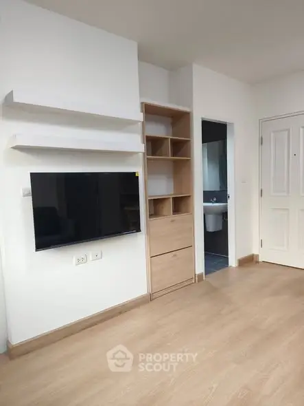 Modern living room with wall-mounted TV and built-in storage, showcasing sleek design and functionality.