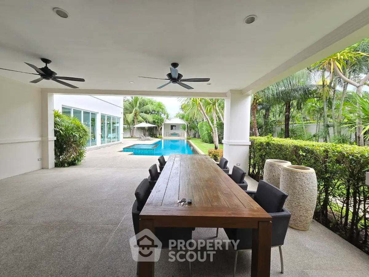 Luxurious outdoor dining area with pool view and lush greenery