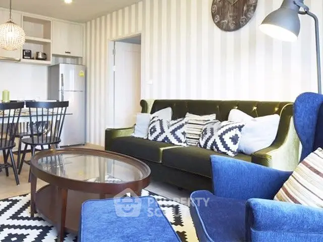 Stylish living room with modern decor, featuring a velvet sofa, patterned cushions, and a glass coffee table.