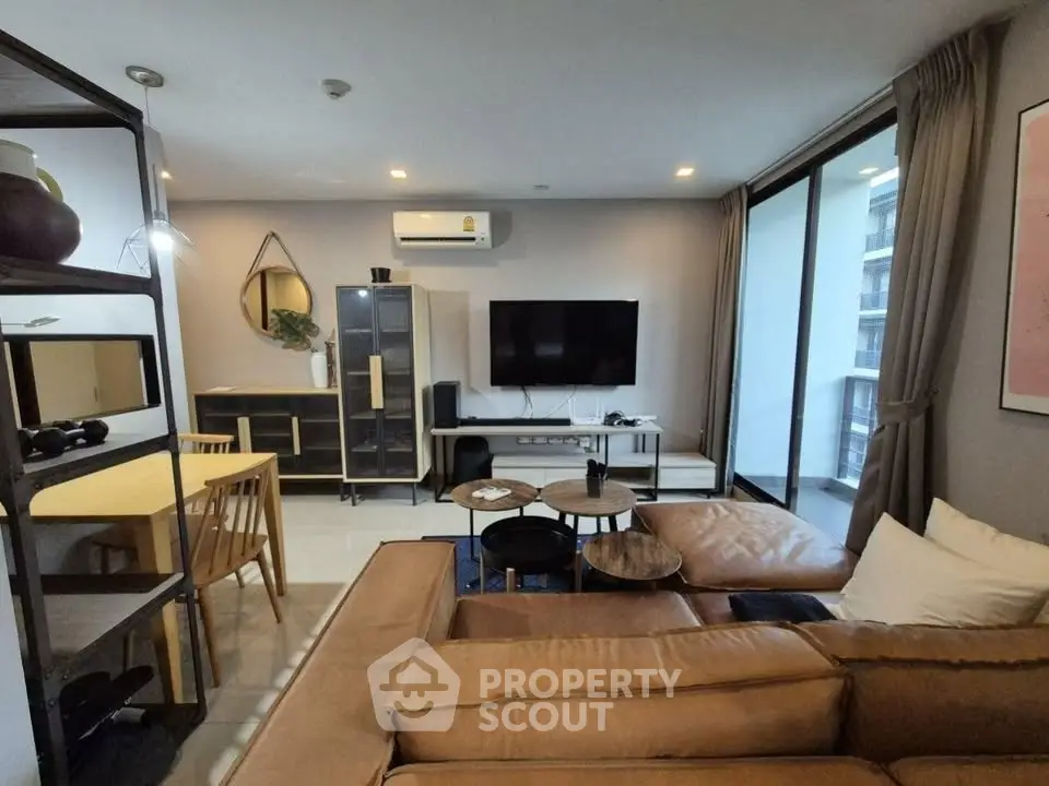 Modern living room with stylish furniture and large balcony access in a contemporary apartment.