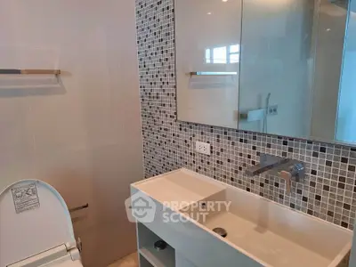 Modern bathroom with sleek sink and mosaic tile backsplash