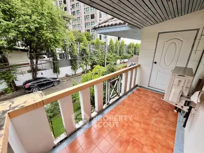 Charming balcony with tiled floor and lush green view in urban setting