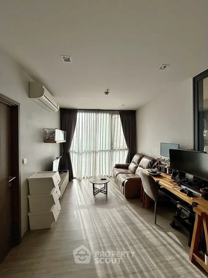 Modern living room with natural light, featuring a cozy sofa, work desk, and stylish decor.