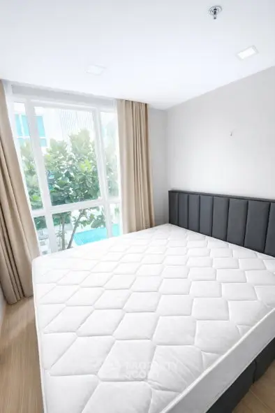 Spacious bedroom with large window and modern decor