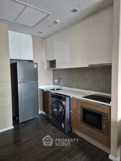 Modern kitchen with sleek appliances and stylish cabinetry in a contemporary apartment.