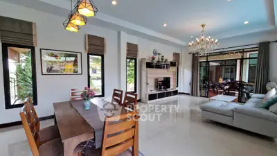 Spacious modern living room with elegant dining area and large windows offering natural light.