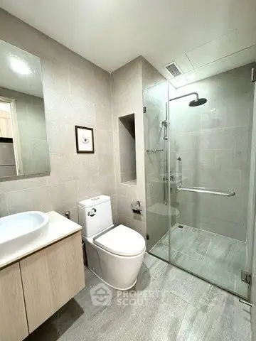 Modern bathroom with glass shower and sleek fixtures in a contemporary home.