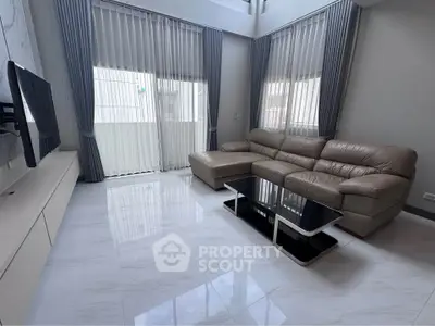 Spacious modern living room with elegant leather sofa and sleek TV setup