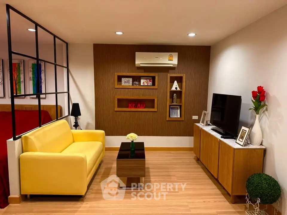 Modern living room with yellow sofa, TV, and stylish decor