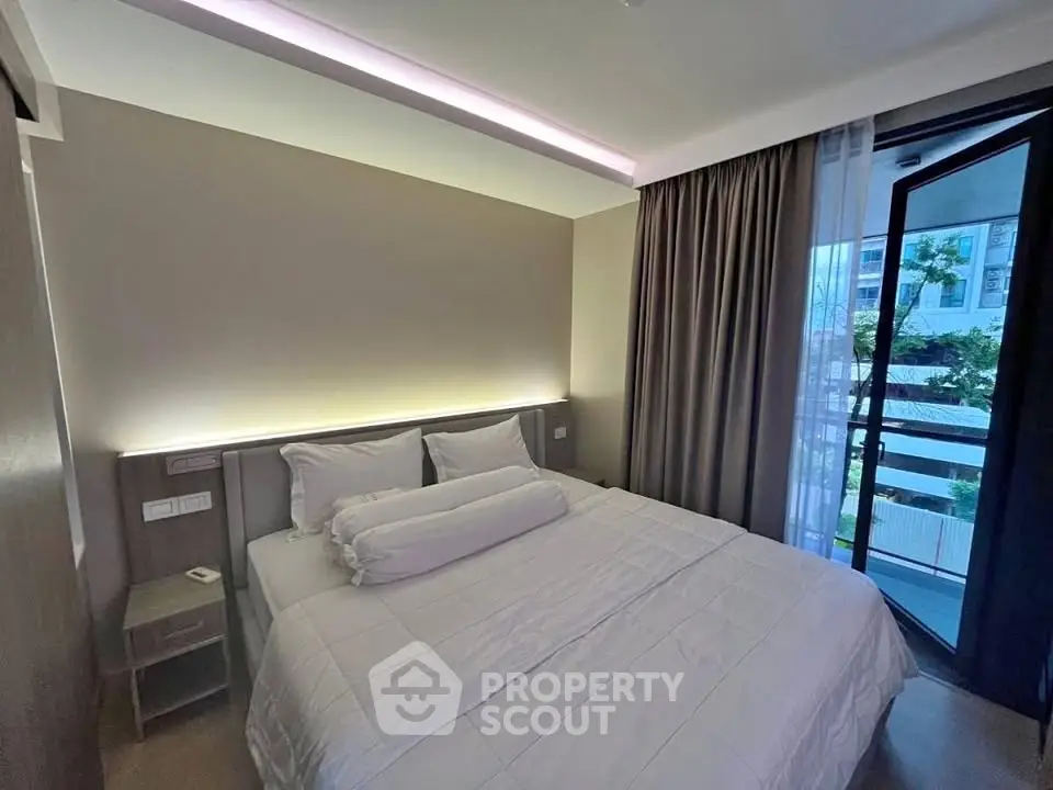 Modern bedroom with balcony access and elegant lighting in a stylish apartment.