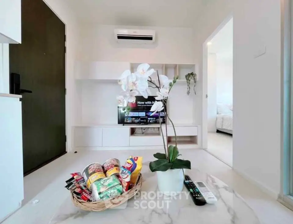 Modern living room with sleek design, featuring a marble table, TV, and air conditioning, perfect for relaxation.