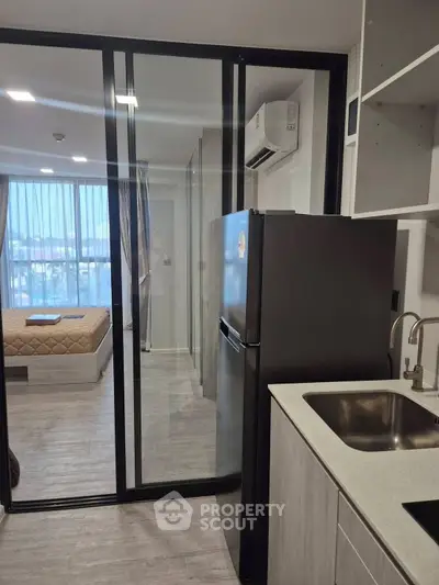 Modern studio apartment with sleek kitchen and cozy bedroom