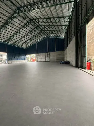 Spacious industrial warehouse with high ceilings and ample natural light, perfect for storage or manufacturing needs.