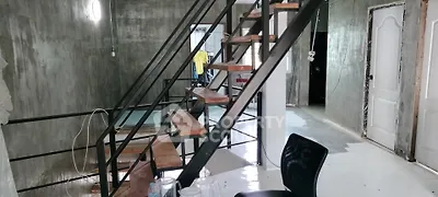 Industrial-style interior with metal staircase and unfinished concrete walls.