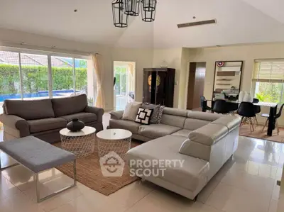 Spacious living room with modern furniture and pool view, perfect for family gatherings.