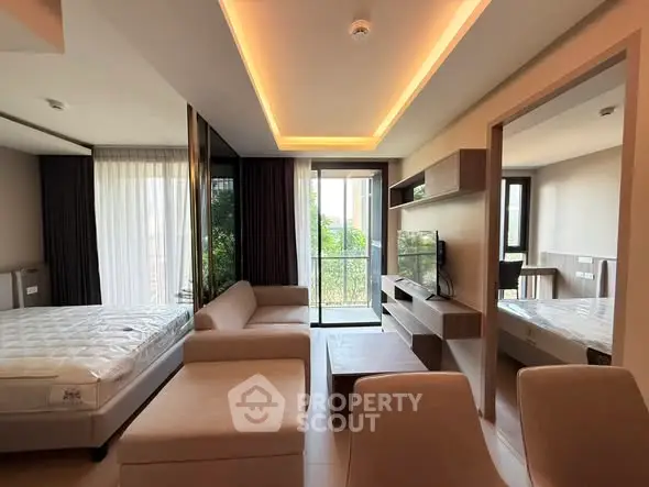 Modern living room with open layout, stylish furniture, and natural light from large windows.