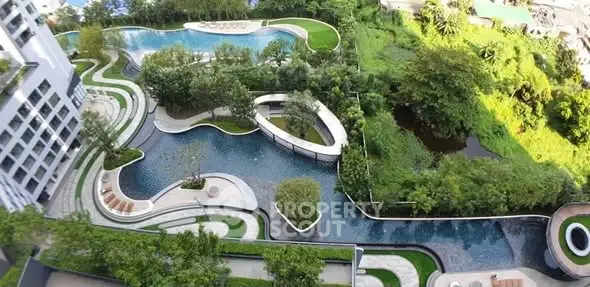 Luxurious residential complex with lush gardens and stunning pool view.
