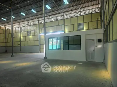 Spacious industrial warehouse interior with high ceilings and ample natural light.