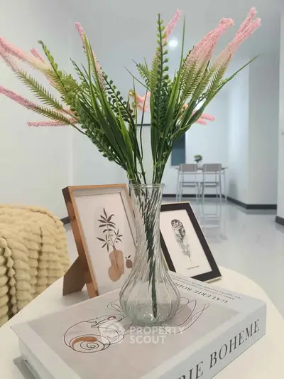 Stylish modern living room with elegant decor and cozy ambiance, featuring a chic vase and framed art.