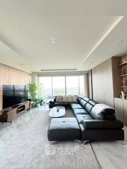 Spacious modern living room with large sectional sofa and floor-to-ceiling windows.