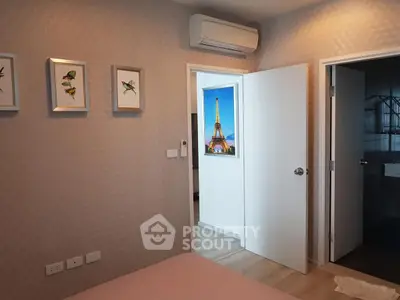 Cozy bedroom with modern decor and air conditioning, featuring a glimpse of a stylish bathroom.