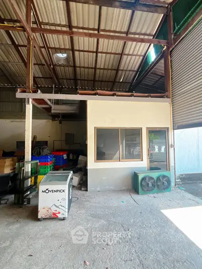 Spacious industrial warehouse with office space and storage area, ideal for business operations.