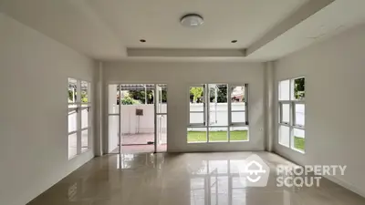 Spacious unfurnished living room with large windows and garden view