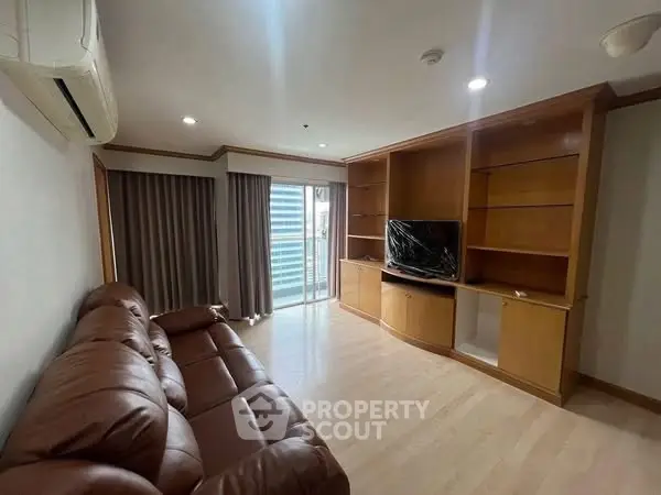 Spacious living room with leather sofa and built-in wooden shelves