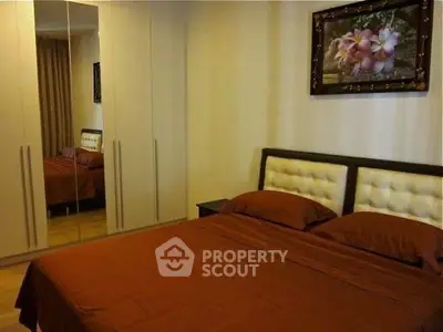 Cozy bedroom with mirrored wardrobe and elegant decor in modern apartment.