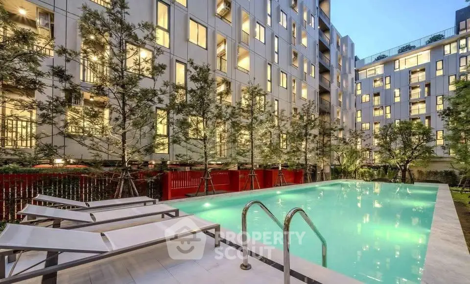 Luxurious apartment complex with a stunning outdoor pool and modern architecture.